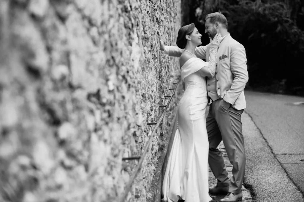 photo noir et blanc de mariés à côté d'un mur en pierre à Cassis