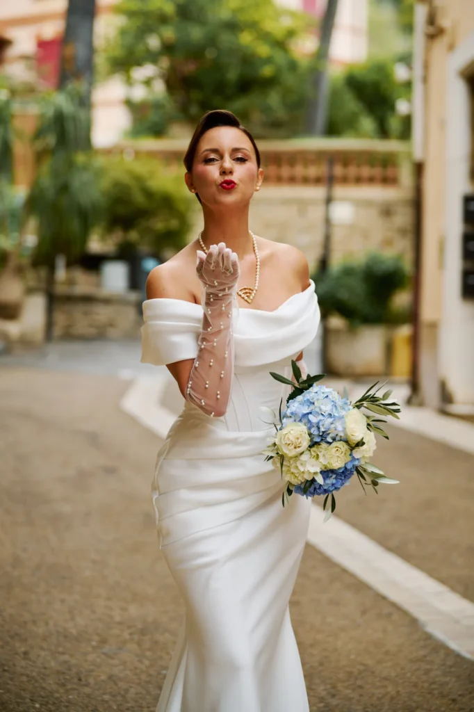 Mariée qui envoi un baiser dans une rue de provence couleur chaude